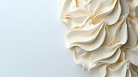 Elegant swirls of creamy white meringue or whipped cream texture creating soft peaks and curves against light background, macro food photography for bakery and dessert designs.