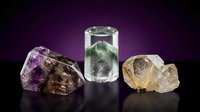Collection of healing crystals and gemstones including amethyst, smoky quartz, and citrine arranged on dark purple gradient background for wellness practices.