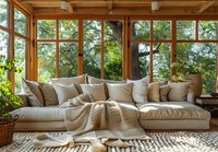 Cozy sunroom interior with large sectional sofa, natural light streaming through panoramic windows, perfect for modern home and lifestyle content creation.