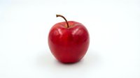 Fresh red apple with brown stem isolated on white background for healthy eating and nutrition concepts.