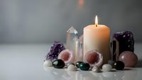 Spiritual healing crystals and gemstones arranged with burning candle for meditation, wellness rituals, and holistic therapy practices.