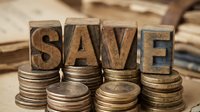 Wooden letter blocks spelling SAVE stacked on coin piles representing financial savings, budgeting and money management concepts for business use.