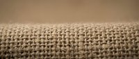Natural burlap fabric texture with woven hemp fibers in close-up macro view showing detailed textile pattern for rustic craft projects and organic material backgrounds.