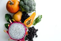 Fresh tropical dragon fruit, pumpkin, papaya, broccoli and blackberries arranged on white background. Colorful healthy food composition with copy space.
