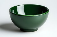 Empty dark green ceramic bowl on white background with soft shadow, minimalist tableware design for modern kitchen and dining presentation.