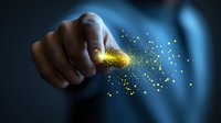 Magical glowing gold dust particles trailing from finger against dark background creates ethereal effect for fantasy and creative concepts.