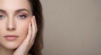 Young Caucasian woman with natural makeup touching face gently, skincare and beauty concept for cosmetic products and wellness treatments.