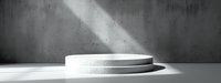 Minimalist white round podium with dramatic light beam in dark concrete interior, modern product display platform for luxury presentation.