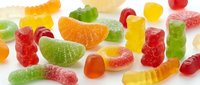 Colorful assorted gummy candies and jelly sweets scattered on white background. Chewy fruit-flavored confectionery treats for snacking and celebrations.