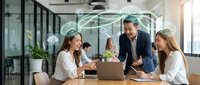 Diverse business team collaborating on digital innovation strategy in modern office workspace with laptop and holographic interface overlay for technology solutions.
