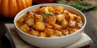 Roasted butternut squash cubes with herbs in white bowl, autumn harvest vegetable side dish for Thanksgiving dinner and holiday meals.