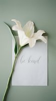 White lily flower with a calligraphy be kind card on sage green background, minimal flat lay for wellness, motivation, and lifestyle content.