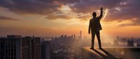 Silhouette of businessman standing on rooftop edge overlooking cityscape at sunset, arm raised in victory gesture, representing success, ambition, and achievement in urban environment.