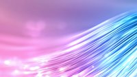Glowing optical fiber strands in pink and blue gradient background create dynamic motion effect with light trails and streaming energy lines.