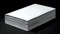 Stack of white paper sheets casting shadow on dark background, minimalist office supplies composition for business and education concepts.