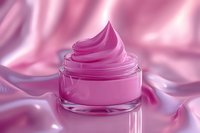 Luxurious pink cosmetic cream in glass jar with swirled texture on silky fabric background for skincare and beauty product marketing campaigns.