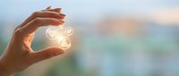 Hand holding glowing light bulb with interconnected nodes symbolizing innovation, ideas, and smart technology solutions for business growth.