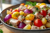 Fresh pasta salad with colorful cherry tomatoes, dill, red onions and tender chicken pieces in ceramic bowl, close up view of Mediterranean cuisine.