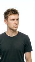 Young adult male with light skin tone and short brown hair wearing a black t-shirt, isolated on white background for portrait and headshot use.