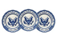 United States 250th anniversary commemorative plates featuring eagle emblem and shield, blue and white porcelain design, historical patriotic dinnerware for collectors and celebrations.