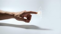 Male hand pointing at glowing digital human figure hologram on white background representing futuristic technology and human-computer interaction concepts.