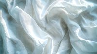 Ethereal white silk fabric with soft folds and gentle waves creates dramatic light and shadow play. Luxurious textile background for fashion and wedding designs.