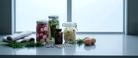 Fermented vegetables in glass jars on kitchen counter with fresh herbs and ingredients for healthy gut microbiome and probiotic nutrition.
