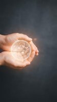 Caucasian hands holding glowing globe sphere against dark background, representing global business, technology innovation, and worldwide connectivity for corporate and environmental concepts.