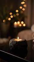 Cozy candle burning in rustic stone holder with warm bokeh lights creating peaceful ambiance for relaxation and meditation at home.