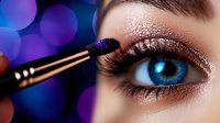 Close-up of woman's blue eye with glittery bronze eyeshadow being applied with makeup brush against purple bokeh background.