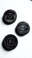 Three wooden contact icons featuring telephone, email, and at symbol on textured dark circles against white background for communication and business design projects.