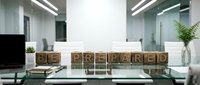Wooden blocks spelling prepared on modern office desk with computer, plants, and glass partitions in contemporary workspace.