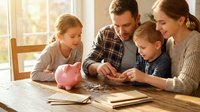 Happy Caucasian family with two children counting coins at wooden table with pink piggy bank, teaching kids about money management and savings at home.