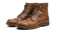 Brown leather work boots with laces isolated on white background for fashion and footwear design projects.
