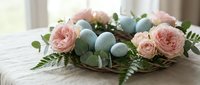 Easter table centerpiece with pink roses, blue eggs and eucalyptus leaves on rustic wooden surface for spring holiday decoration and festive dining.