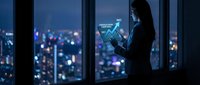 Professional businesswoman analyzing financial data on tablet with holographic charts against city skyline at night for corporate presentations.