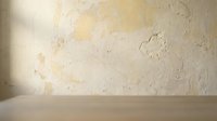 Warm beige textured wall background with natural lighting and wooden surface for product display, interior design and advertising presentations.