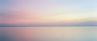 Serene dawn seascape with soft pink and blue hues reflecting on calm water, conveying tranquility and peaceful morning atmosphere for wellness and meditation projects.