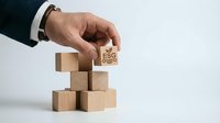 Professional businessman hand placing wooden cube with ESG text on stack of blocks representing environmental social governance investment strategy.