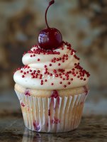 Gourmet cupcake with white frosting, red sprinkles and cherry on top. Sweet dessert for bakery menu, celebration or food photography projects.