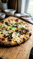 Freshly baked pizza with melted cheese, caramelized onions, and basil on wooden cutting board in bright kitchen setting with ceramic bowls and linen cloth.