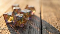 Colorful metal polyhedral dice set with intricate engravings on rustic wooden surface for tabletop gaming and role-playing adventures.