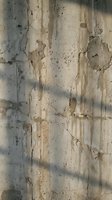 Weathered concrete wall with peeling paint and cracks showing urban decay and industrial texture for architectural backgrounds and grunge design projects.