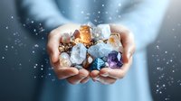 Magical glowing crystals and gemstones in cupped hands with sparkles and light effects against blurred background, spiritual healing concept.
