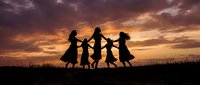 Four women silhouettes holding hands dancing in circle against dramatic sunset sky with purple and orange clouds creating joyful friendship moment.