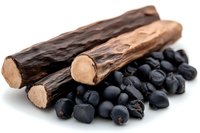 Dried licorice root sticks and black juniper berries on white background, natural herbal medicine ingredients for tea, supplements and aromatherapy.