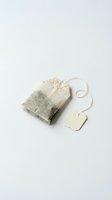Tea bag with blank tag on white background, suitable for product packaging, branding, and beverage marketing materials.