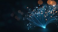 Glowing blue optical fiber strands emanating from single point with bokeh light effects on dark background, modern technology and connectivity concept.
