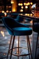 Luxurious teal velvet bar stool with gold metal legs in elegant restaurant interior with warm bokeh lights and reflective sphere decoration on table.