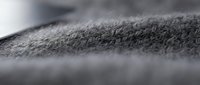 Close-up of gray textile fabric surface with soft, fuzzy texture and shallow depth of field, suitable for backgrounds and material design projects.
